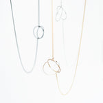 This simple geometric lariat necklace can be worn flat against the body or with the circle charms pulled together for a more three-dimensional look
