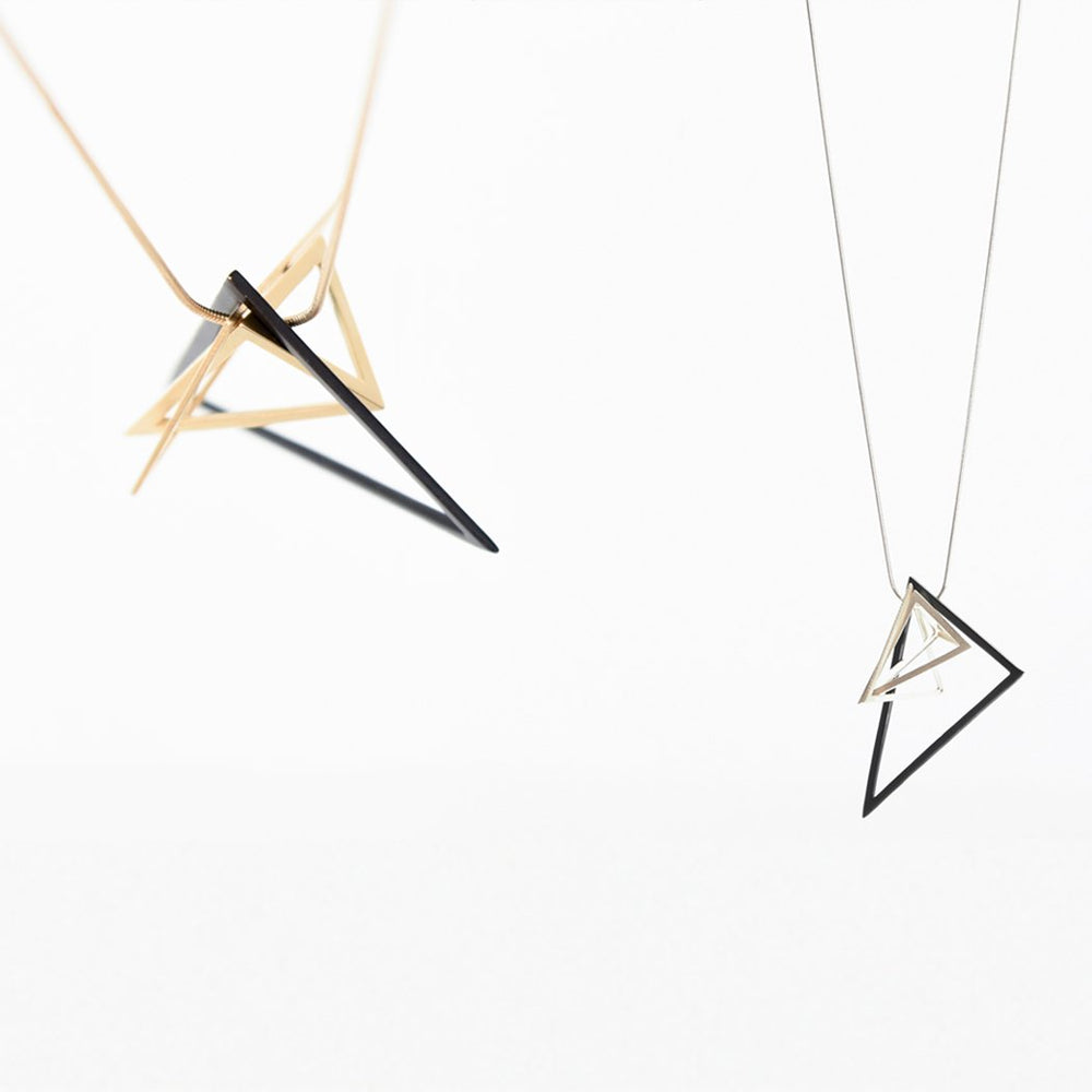 The triangular pendants of this necklace give this design a fun and energetic allure. Hanging on either a gold or silver snake chain, this mix of colours and tones creates an exciting contrast.