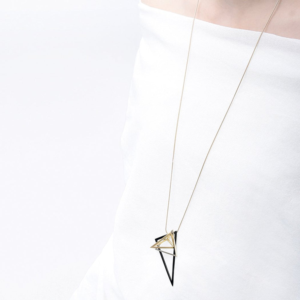 The triangular pendants of this necklace give this design a fun and energetic allure. Hanging on either a gold or silver snake chain, this mix of colours and tones creates an exciting contrast.