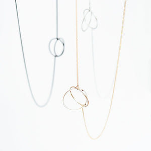 
                  
                    This simple geometric lariat necklace can be worn flat against the body or with the circle charms pulled together for a more three-dimensional look
                  
                