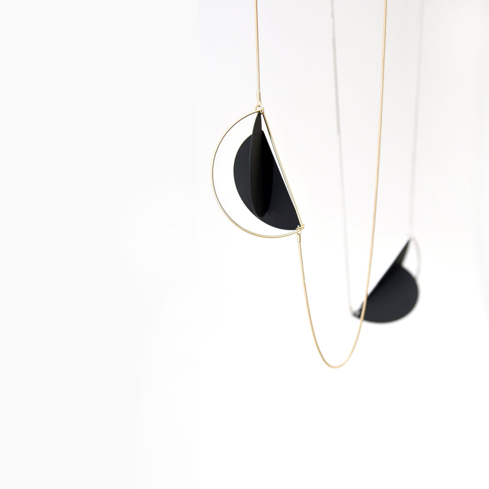 The dramatic impact of this statement necklace is made by the two angled discs. Together they give a sense of depth and three-dimensionality to a pendant that actually lies completly flat