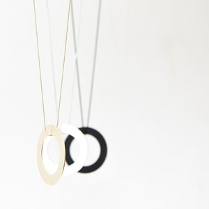 
                  
                    This bold circle pendant is a statement piece. Each round ring has matte finish in gold, silver, or black.
                  
                