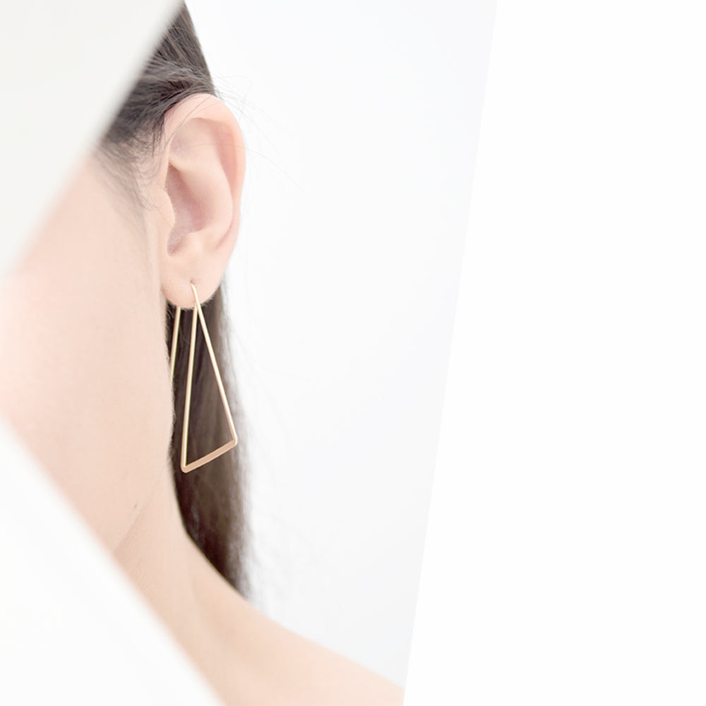 A simple geometric pair of triangle ear hoops. Available in gold, silver, rose gold, and black finishes